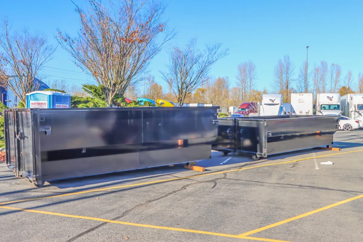 Professional dumpster rental service with roll-off container on residential driveway in Merrimac